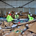Waste sorting workers within a bin collection warehouse