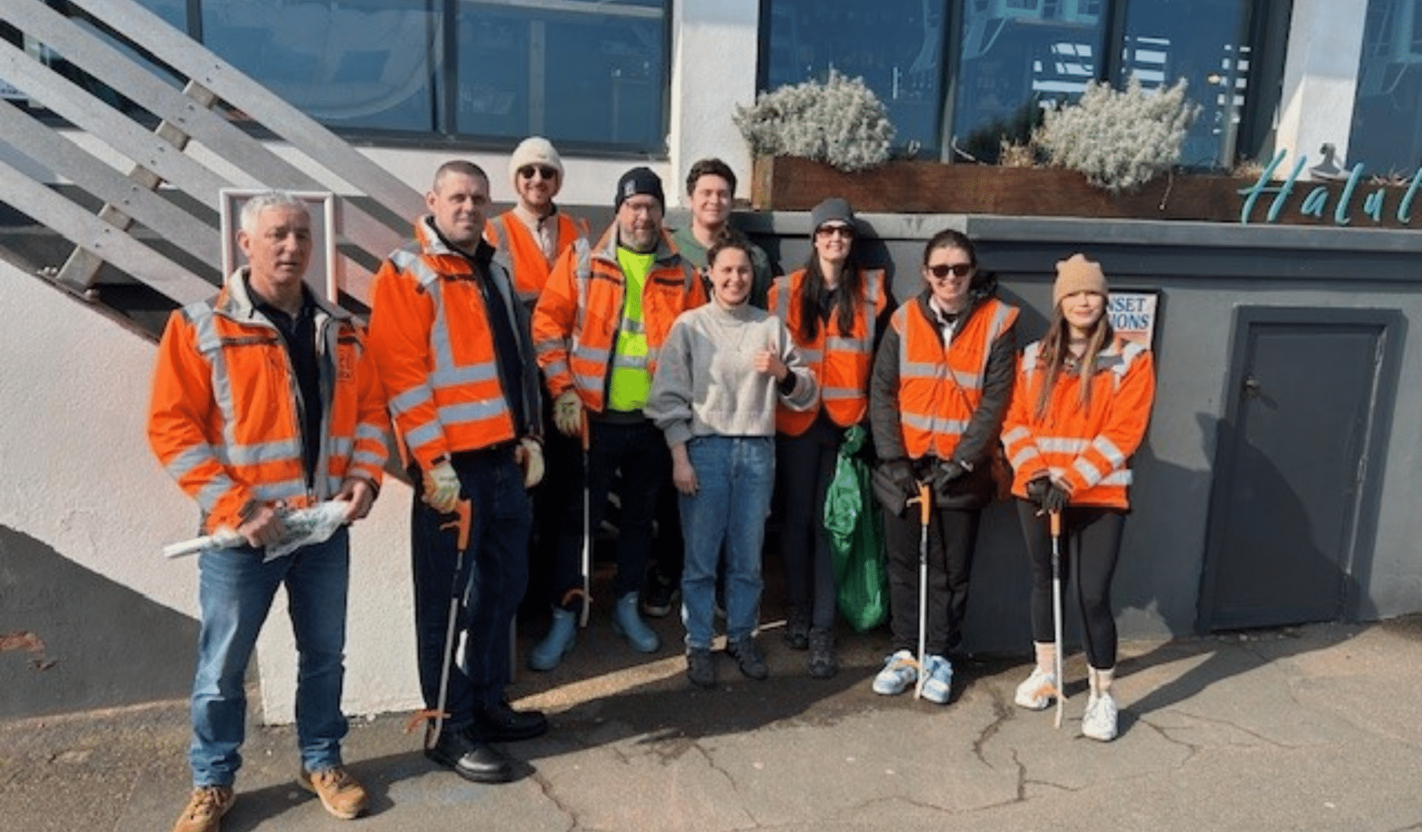 Group photo of beach clean participants in high vis!