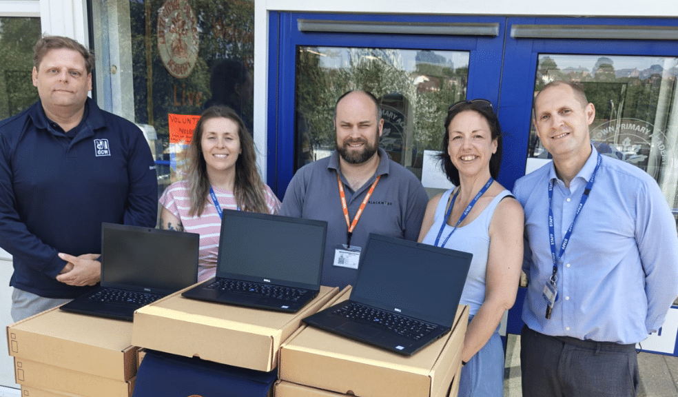 DCW staff donating laptops to a primary school.